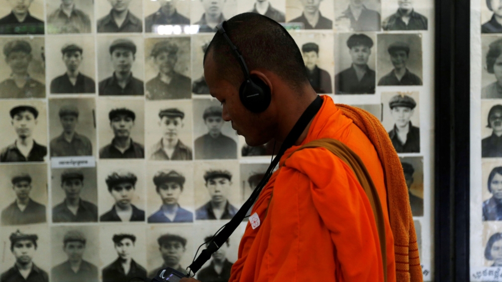 A Buddhist monk looks at pictures of victims of the Khmer Rouge regime at Tuol Sleng Genocide Museum in Phnom Penh