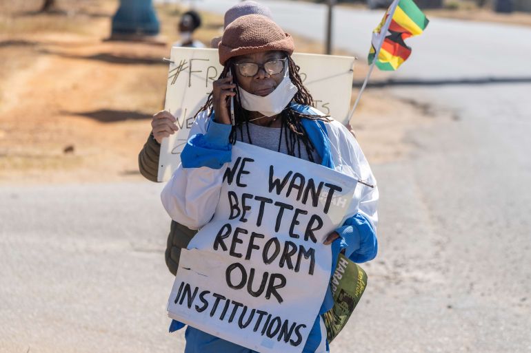 Zimbabwean novelist Tsitsi Dangarembga holds a placard reading 'We want better. Reform our Institutions' during an anti-corruption protest march in Harare in July 2020