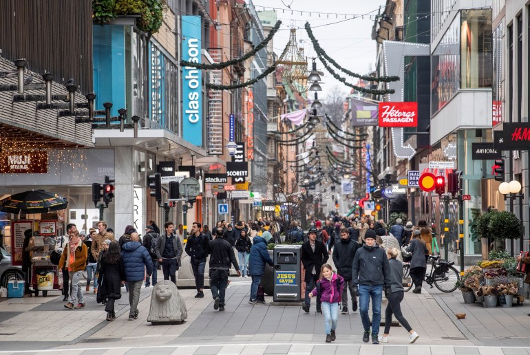 People walk at the Drottninggatan shopping street in Sweden.