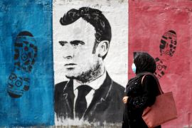 A Palestinian woman walks past an anti-French President Emmanuel Macron mural painted by an artist to protest against the publications of a cartoon of Prophet Mohammad in France and Macron&#39;s comments, in Gaza City, October 28, 2020. [Mohammed Salem/Reuters]