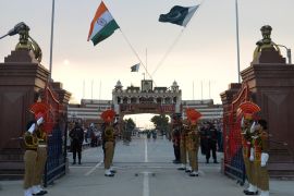 Pakistani Rangers and Indian Border Security Force (BSF) personnel salute their national flags as they perform during the daily beating of the retreat ceremony on the India-Pakistan Border at Wagah on February 20, 2017 [File: AFP/Narinder Nanu]
