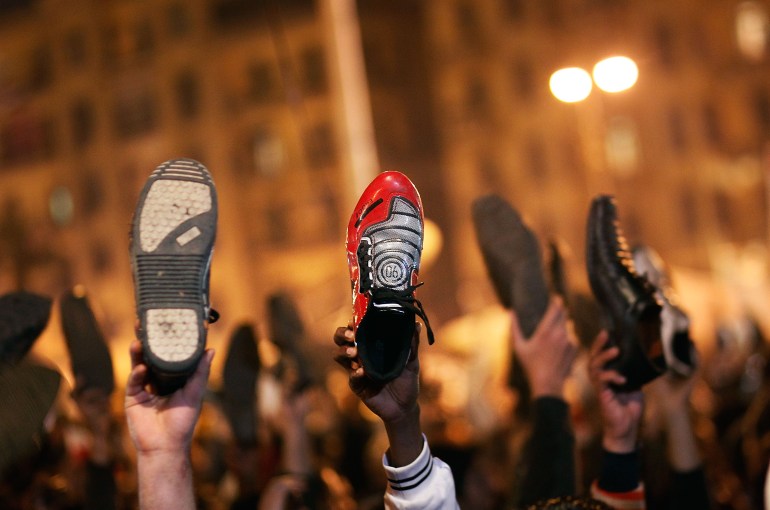 CAIRO, EGYPT - FEBRUARY 10: Anti-government protesters raise their shoes after a speech by Egyptian President Hosni Mubarek February 10, 2011 in Cairo, Egypt. President Hosni Mubarak made a statement saying that he had given some powers to his vice president but would not resign or leave the country, leaving a crowd of anti-government protesters disappointed and furious after early reports he might step down. (Photo by Chris Hondros/Getty Images)