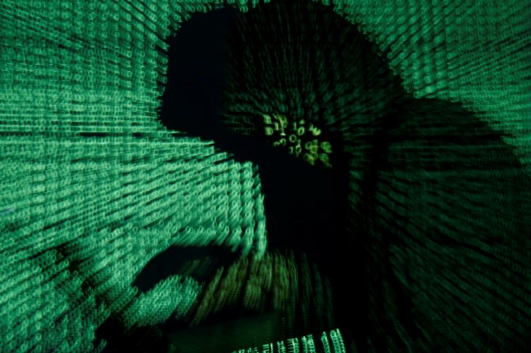 A man holds a laptop computer as cyber code is projected on him in this illustration.