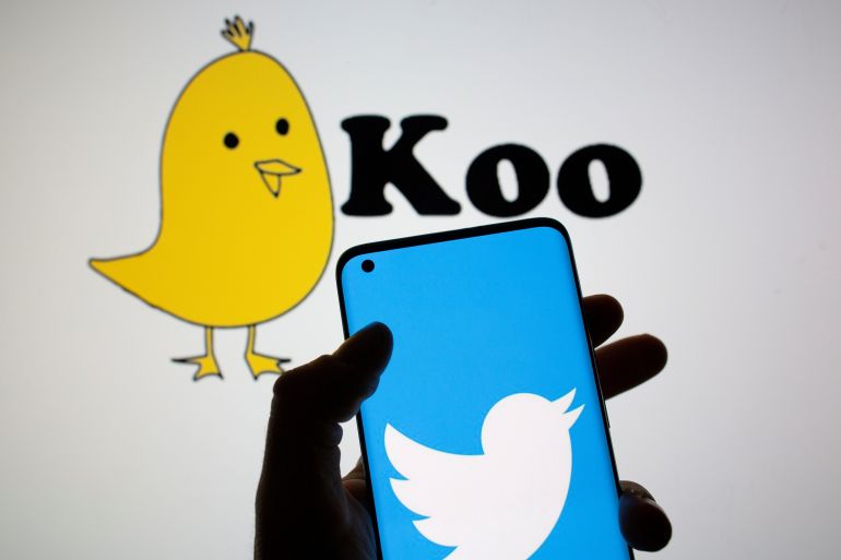 Twitter logo is seen on smartphone in front of displayed Koo app logo in this illustration