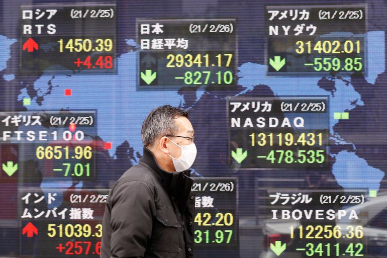 A man walks past stock figures in Japan.