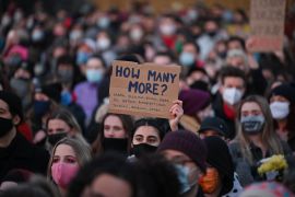 Well-wishers, one with a placard that reads &quot;How many more&quot;, gather at for a vigil in honour of murder victim Sarah Everard, in Clapham, south London, on March 13, 2021. [Justin Tallis/AFP]
