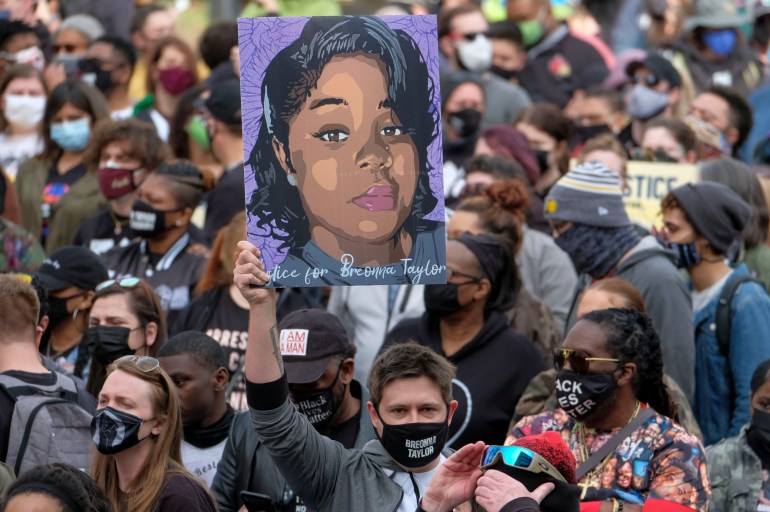 A protestor brandishes a portrait of Breonna Taylor 