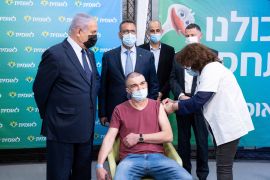 Israeli Prime Minister Benjamin Netanyahu meets the 4,000,000th person who had been vaccinated in Israel on February 16, 2021 [Alex Kolomoisky/Pool via Reuters]