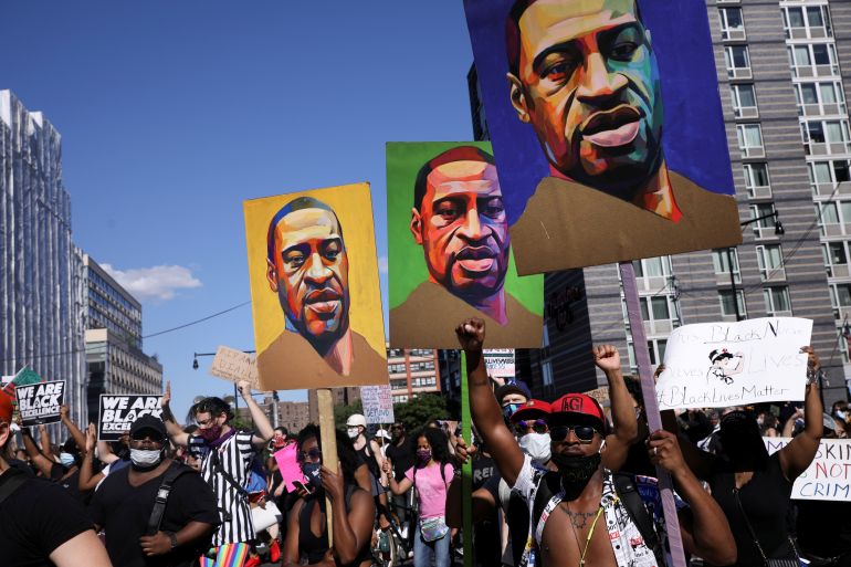 FILE PHOTO: Demonstrators hold signs depicting George Floyd, who died in Minneapolis police custody, during a protest against police brutality and racial inequality as the outbreak of the coronavirus disease (COVID-19) continues in Brooklyn, New York, U.S., June 13, 2020. REUTERS/Caitlin Ochs/File Photo/File Photo