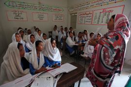 A teacher shows students a flash card while describing measures to take when sexual harassment occurs, during a class in Shadabad Girls Elementary School in Gohram Panhwar in Johi, Pakistan [File: Reuters/Akhtar Soomro]