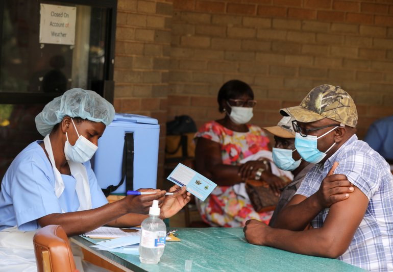 A man receives a certificate after being vaccinated against the coronavirus disease (COVID-19) at Wilkins Hospital in Harare, Zimbabwe