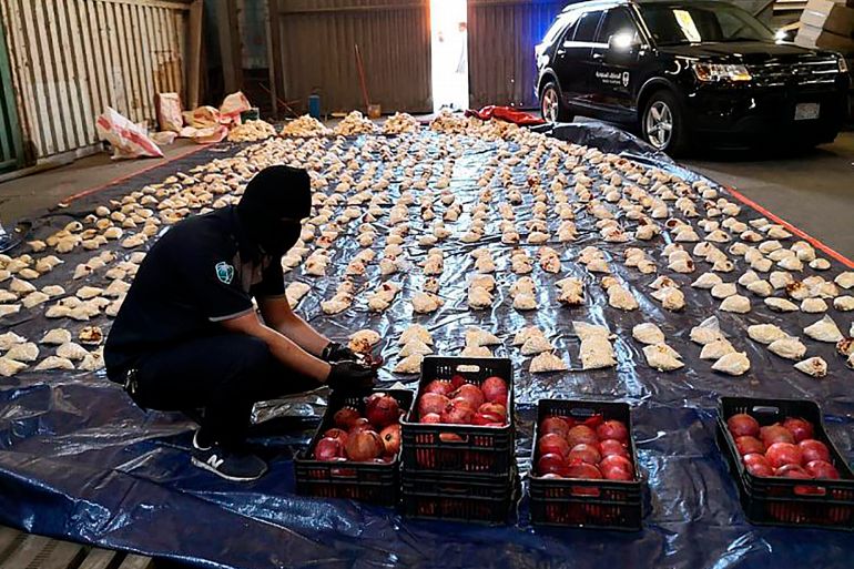 Saudi custom officer opens imported pomegranates, as customs foiled an attempt to smuggle over 5 million Captagon pills in 2021 [File photo: Saudi Press Agency/AP]