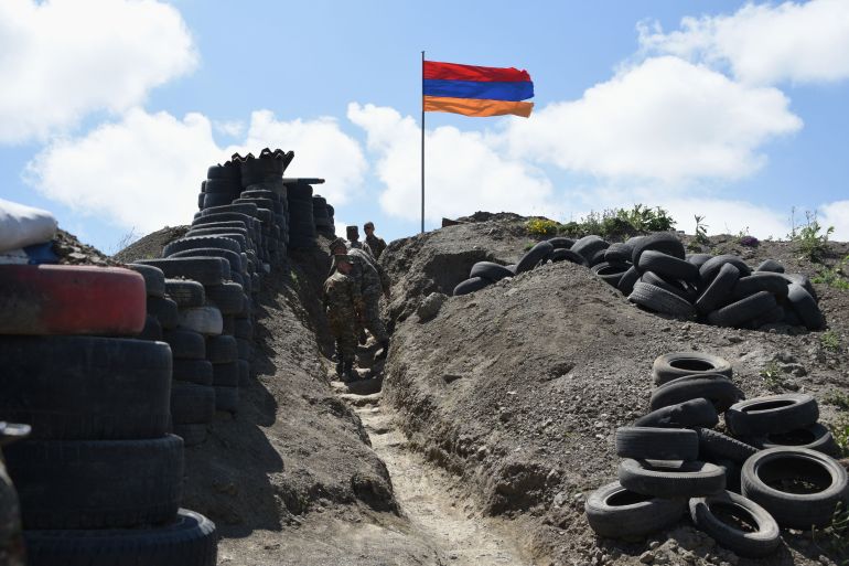 Soldiers walk in a trench at a border check point between Armenia and Azerbaijan near the village of Sotk, Armenia