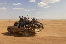 Armed men on a pick up truck in the desert