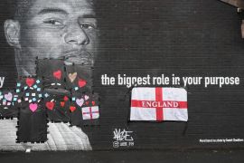 Messages of support cover racist graffiti on the vandalised mural of England and Manchester United striker Marcus Rashford on a wall in Withington, Manchester [Christopher Furlong/Getty Images]