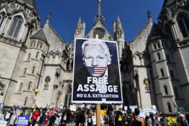 Supporters hold placards in support of WikiLeaks founder Julian Assange outside the Royal Courts of Justice in London on August 11, 2021, during a preliminary appeal hearing of the US case for the extradition of Assange to the US [File: Justin Tallis/AFP]