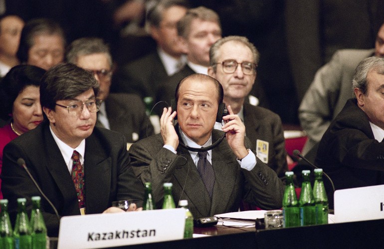 Italian Prime Minister Silvio Berlusconi puts on his earphones to be prepared for the first session of the CSCE summit meeting held in the Convention Center of Budapest, attended by 53 countries, Dec. 5, 1994. (AP Photo/Rudi Blaha)