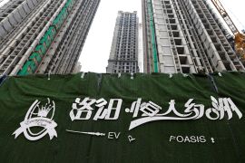 A peeling logo of the Evergrande Oasis, a housing complex developed by Evergrande Group, is pictured outside the construction site where the residential buildings stand unfinished, in Luoyang, China