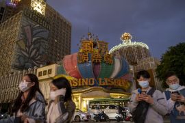 People walking past casinos in Macau, China.