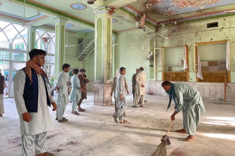 Afghan men inspect the damages inside a Shiite mosque in Kandahar on October 15, 2021