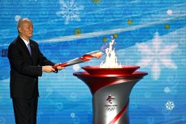 A man lights a torch to mark the Winter Olympics in Beijing.