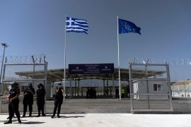 A Greek national flag and a European Union flag flutter at a newly inaugurated closed-type camp for asylum seekers on the island of Samos on September 18, 2021 [File: Alkis Konstantinidis/Reuters]