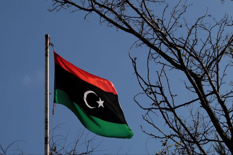 A Libyan flag flutters in the air.