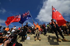Protesters wave flags as they gather at the Shrine of Remembrance as they rally against mandatory COVID-19 vaccinations and a two-week shutdown of the construction industry, in Melbourne, Victoria, Australia, 22 September 2021. [James Ross/EPA-EFE]