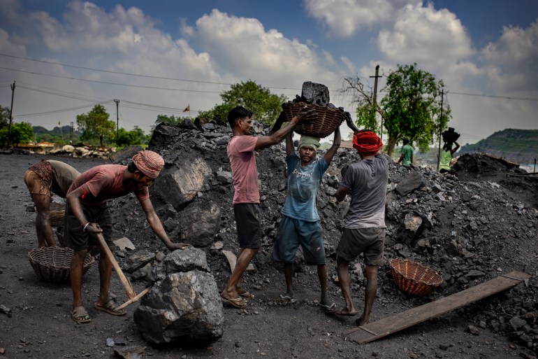 Laborers load coal onto trucks for transportation near Dhanbad, an eastern Indian city in Jharkhand state, Friday, Sept. 24, 2021. A 2021 Indian government study found that Jharkhand state -- among the poorest in India and the state with the nation’s largest coal reserves -- is also the most vulnerable Indian state to climate change. Efforts to fight climate change are being held back in part because coal, the biggest single source of climate-changing gases, provides cheap electricity and supports millions of jobs. It's one of the dilemmas facing world leaders gathered in Glasgow, Scotland this week in an attempt to stave off the worst effects of climate change.