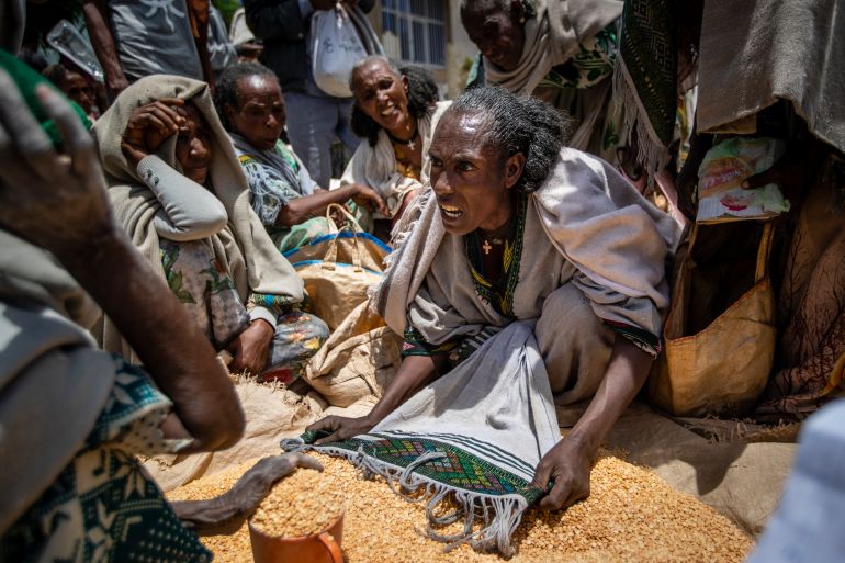 FILE - An Ethiopian woman argues with others over the allocation of yellow split peas after it was distributed by the Relief Society of Tigray in the town of Agula, in the Tigray region of northern Ethiopia