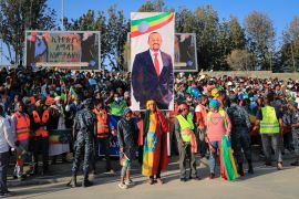 People gather under a placard showing Prime Minister Abiy Ahmed at a rally organised by local authorities to show support for the Ethiopian National Defense Force, at Meskel square in downtown Addis Ababa, Ethiopia, November 7, 2021 [File: AP Photo]