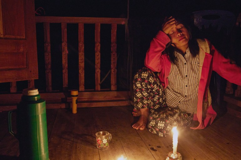 A young woman sits in the candlelight before going to bed early at her place of work in Dae Pu Noh, Mutraw district. Many people in Karen state stopped using electric lights in the evenings following Tatmadaw airstrikes so that their villages could not be so easily spotted by Tatmadaw aircraft flying overhead. [Al Jazeera] - DO NOT USE