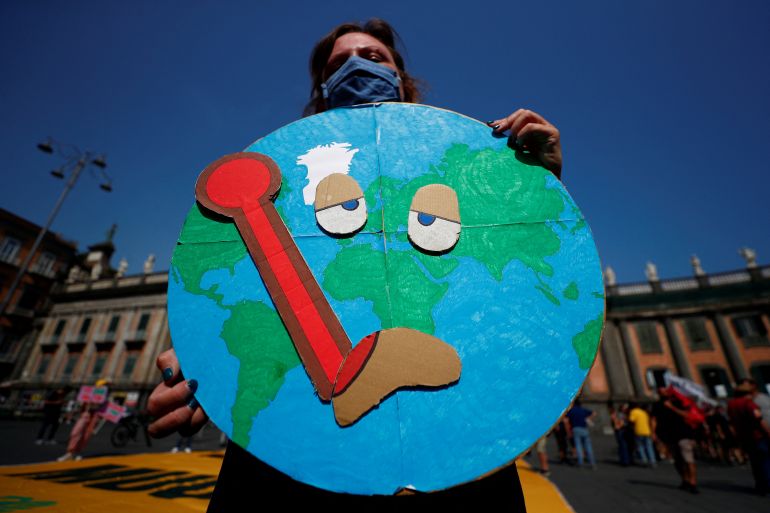A protester holds a placard during a demonstration demanding more action while G20 climate and environment ministers hold a meeting in Naples, Italy on July 22, 2021