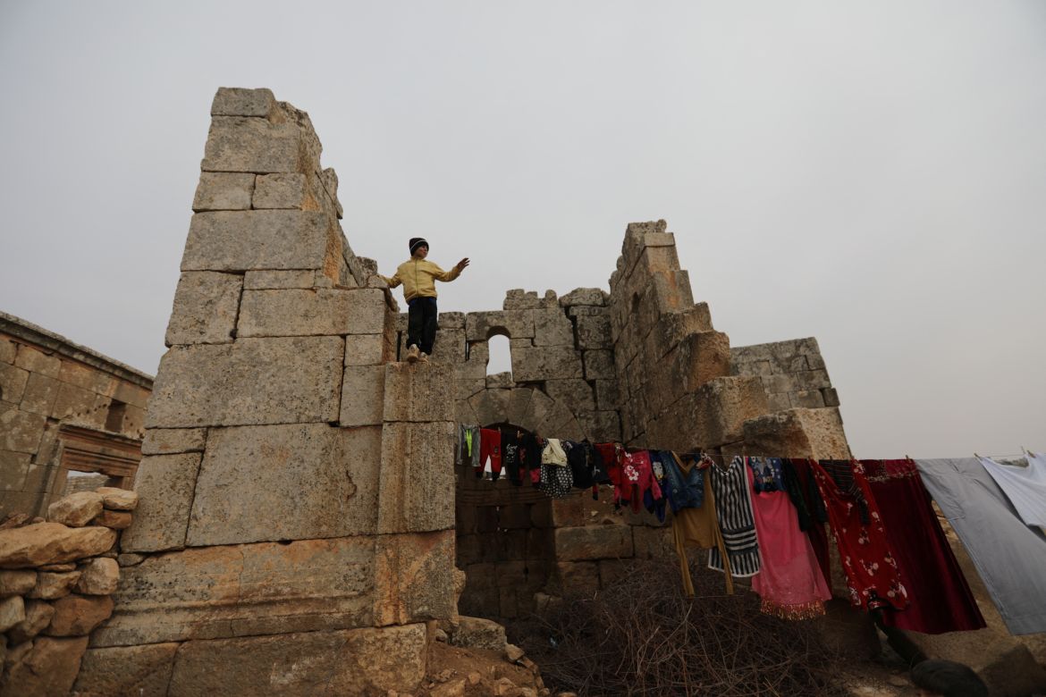 Louay Abu Al-Majd, 11, stands atop ruins at the UNESCO World Heritage Site of Babisqa, Syria