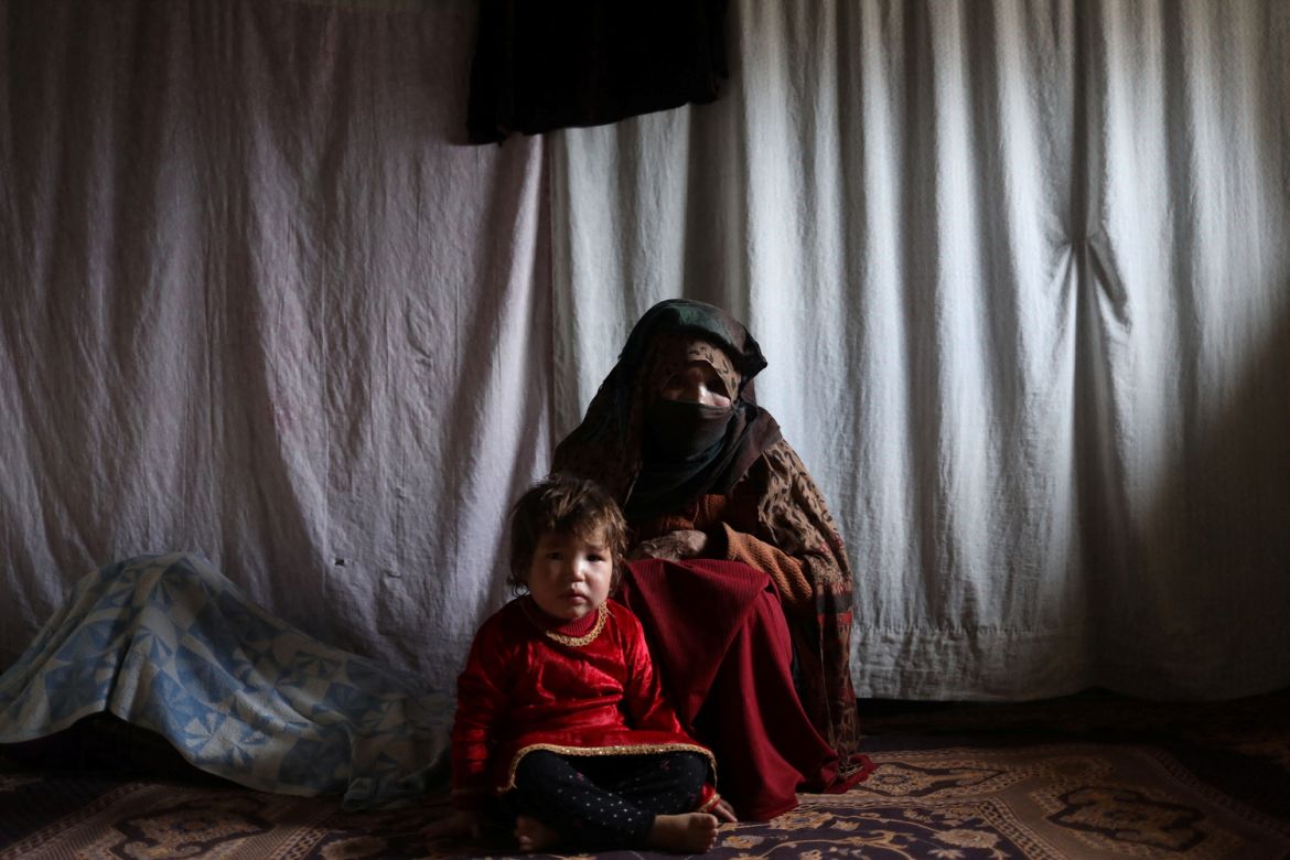 Kubra, sits with her grandchild in a house in Bamiyan, Afghanistan