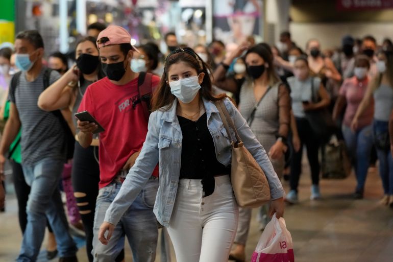Commuters wear protective face masks as they walk through a subway station, in Sao Paulo, Brazil