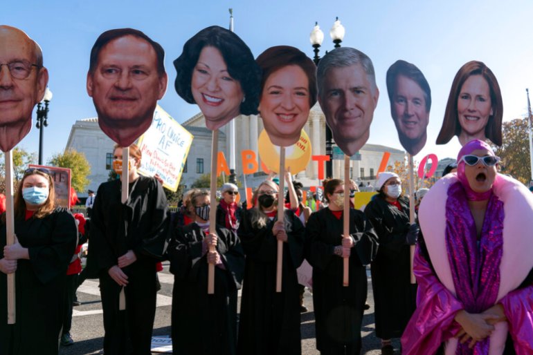 Abortion rights advocates hold cardboard cutouts of Supreme Court justices