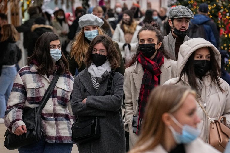 People wearing face masks to protect against COVID-19 walk in Paris