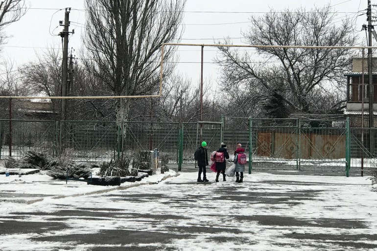 Schoolchildren in Marinka leave school to go home