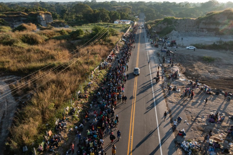 Thousands of migrants and asylum seekers wait along a road in Tapachula, Mexico