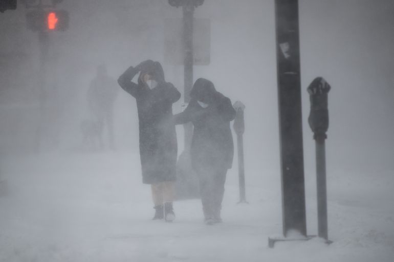 pedestrians walk in a blizzard