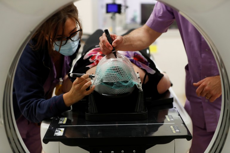 Medical staff fixes the thermoplastic mask on a patient's face before undergoing CT at the UPMC Hillman Cancer Center San Pietro FBF, during the coronavirus disease (COVID-19) outbreak, in Rome, Italy