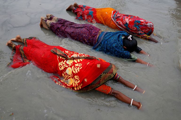 Women worship to Hindu sun god on the banks of Ganges
