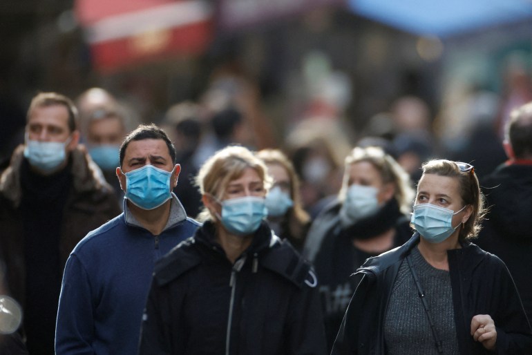 People, wearing protective face masks, walk on the Mouffetard street in Paris