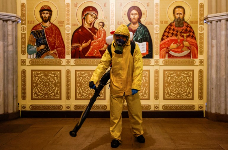 A specialist wearing personal protective equipment sprays disinfectant while sanitizing a chapel inside the building of the Leningradsky railway station in Moscow, Russia 