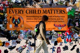A man walks by a banner that reads, 'Every Child Matters', in honour of residential school survivors