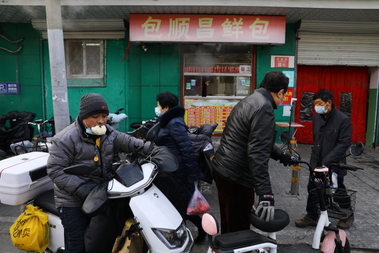 People walk past a market, as the coronavirus disease (COVID-19) pandemic continues in the country, in Beijing, China