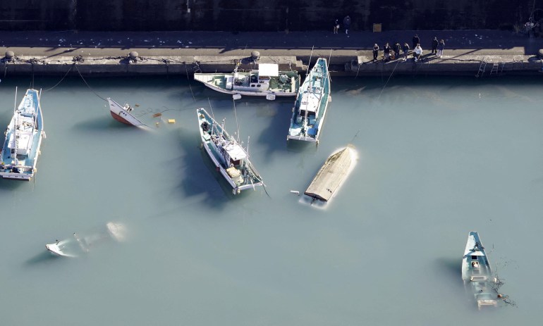 An aerial view shows capsized boats believed to be affected by the tsunami caused by an underwater volcano eruption on the island of Tonga at the South Pacific, in Muroto, Kochi prefecture, Japan.