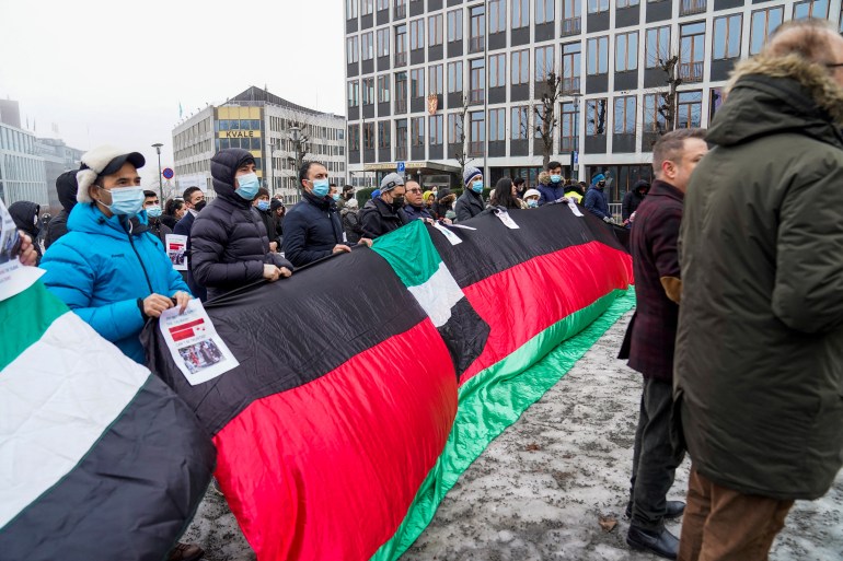 protesters hold a large Afghan flag during Oslo protest against Taliban