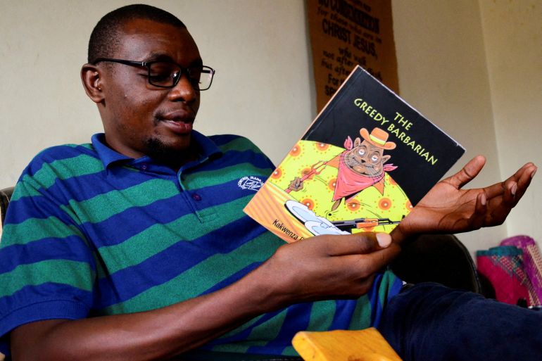 Ugandan author of 'Greedy Barbarian' Kakwenza Rukirabashaija reads the book at his home in Iganga district in Eastern Uganda